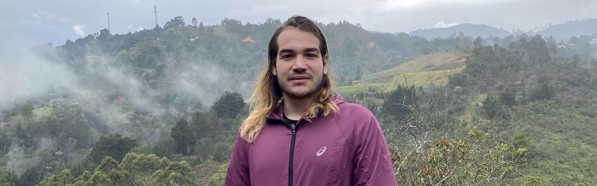 Sebastian Hamid stands ata foggy valley lookout in Colombia