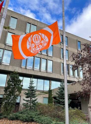 A large orange flag flies outside the U of G University Centre building