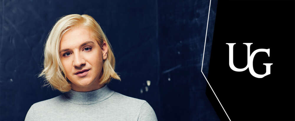 A person smiles for the camera. the UG logo is to the right