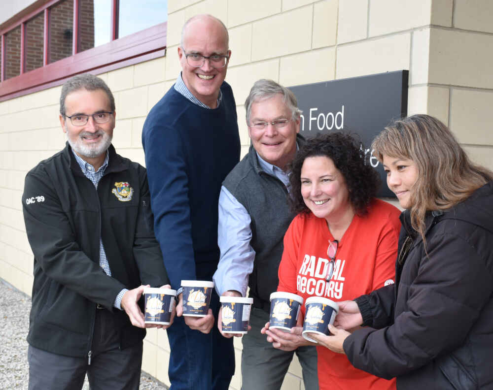 Five people smile and hold containers of Lotsa Local Love ice cream