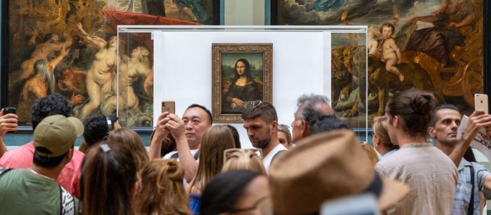 people gathering near Monalisa painting