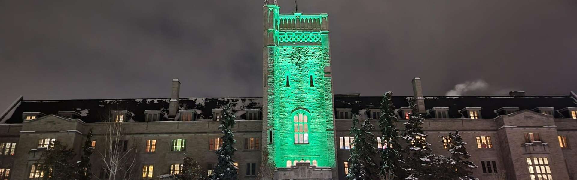 Johnston Hall at night in winter lit in green
