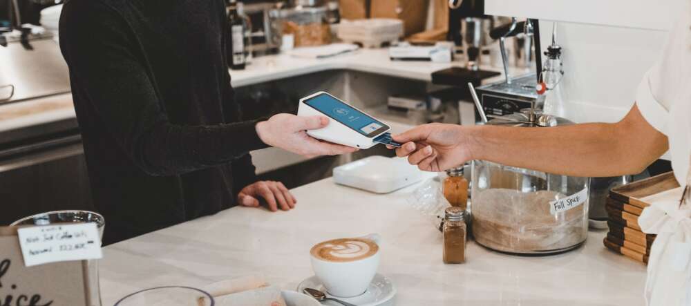 A person pays with a credit card at a coffee shop