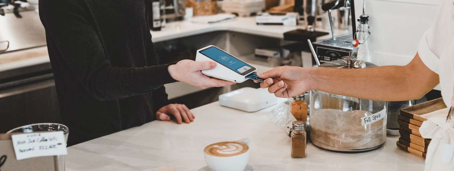 A person pays with a credit card at a coffee shop