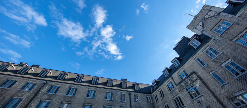 Johnston Hall from as seen from a low angle against a sunny, partly cloudy sky