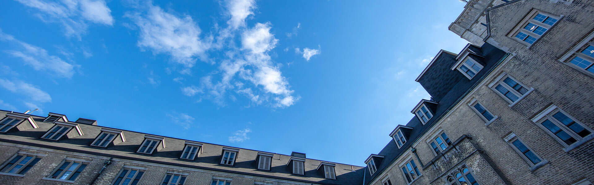 Johnston Hall from as seen from a low angle against a sunny, partly cloudy sky