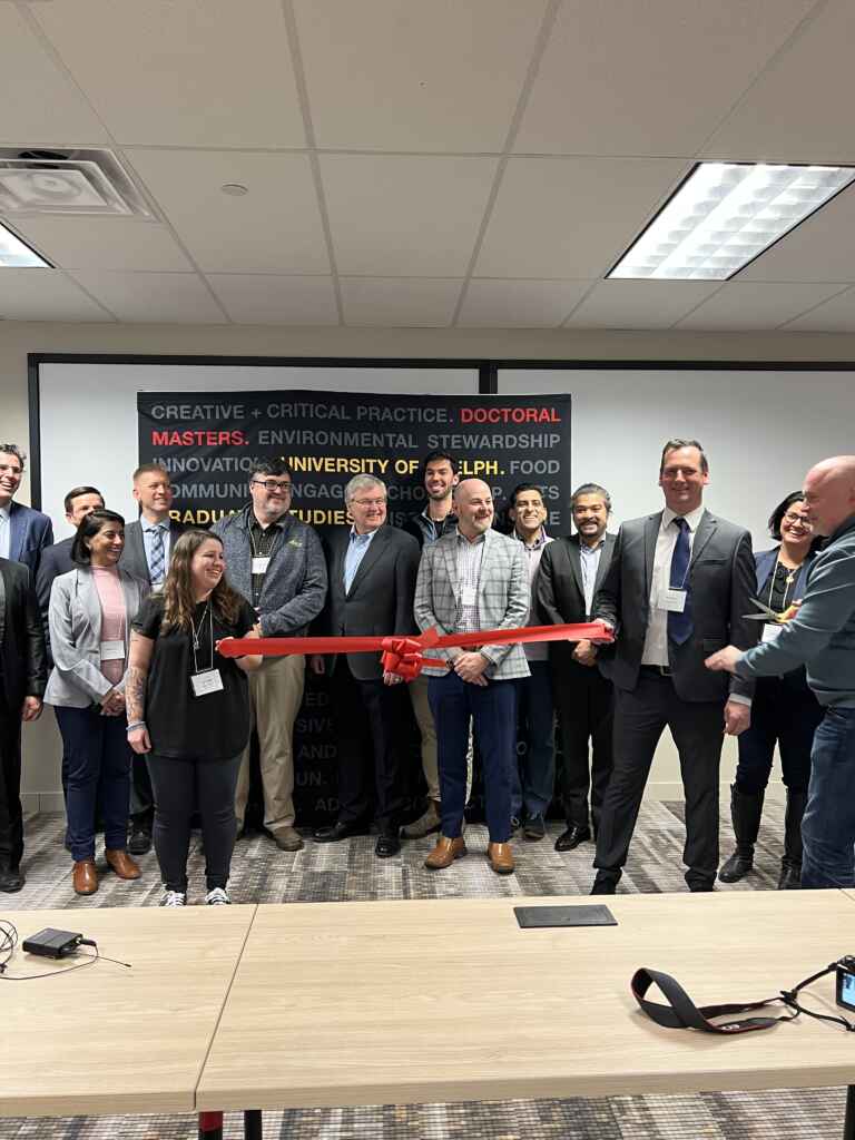 Dave Whittle, U of G's Chief Information Officer, cuts a red ribbon in front of a crowd of partners and faculty during the grand opening of the MCTI Cyber Space