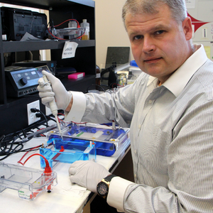Dr. Jim Petrik glances at the camera while working in a lab