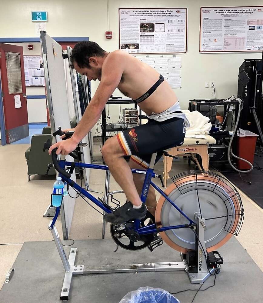 A person wearing shorts rights on a spinning bike in a office lab