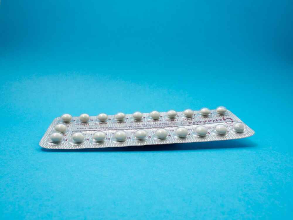 oral contraceptive pill package on a blue backdrop