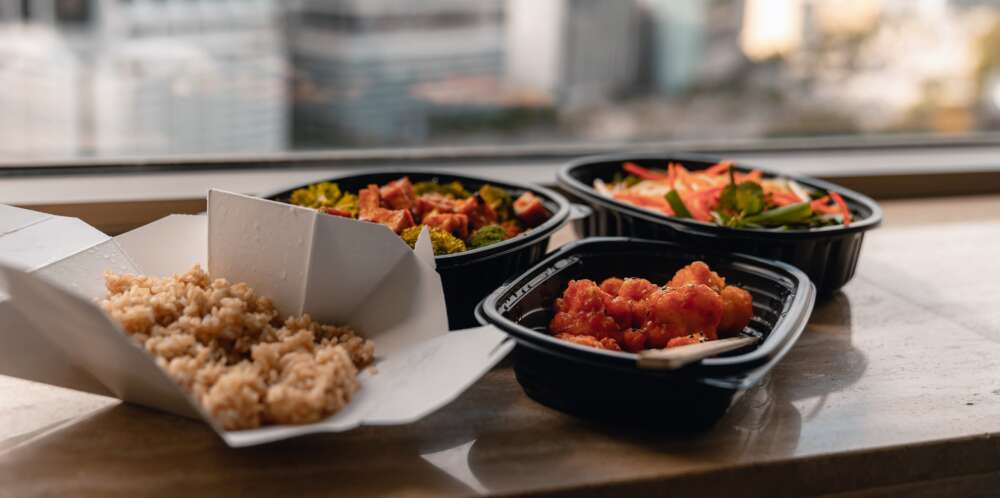 Close-up of takeout food in plastic containers On Table