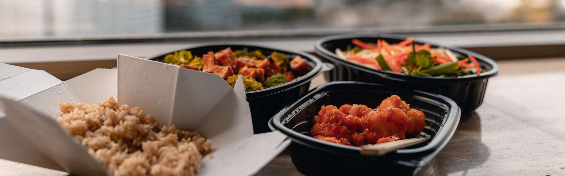 Close-up of takeout food in plastic containers On Table