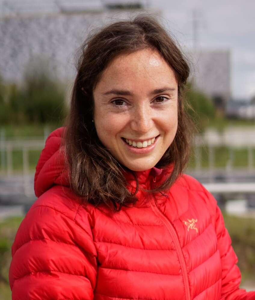 a person in red ski jacket stands for a portrait outside
