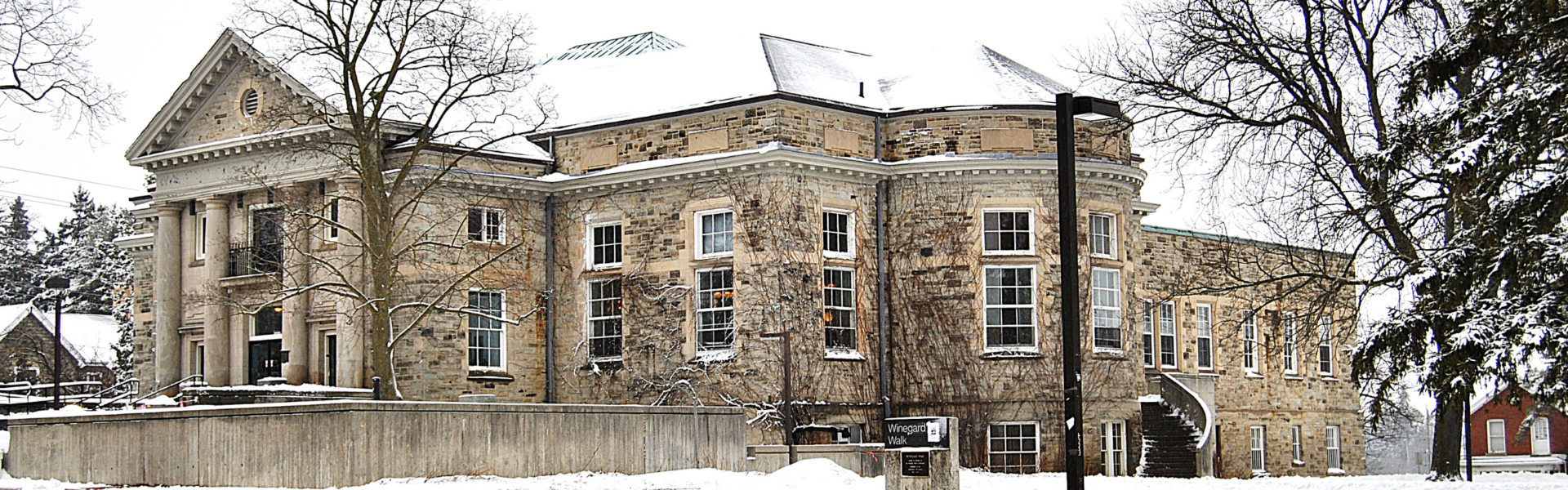 The stone Creelman Hall building in winter with snow