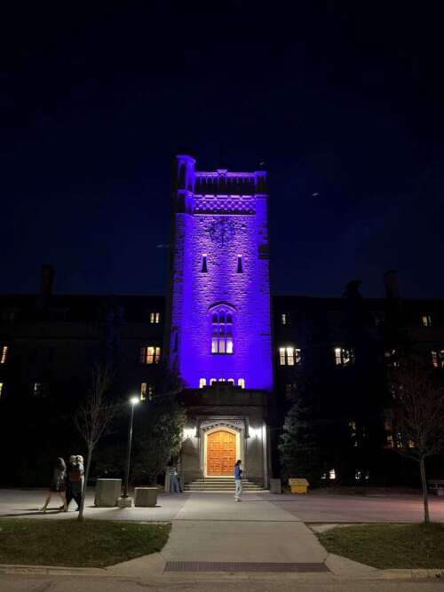 Johnston Hall lit purple at night.