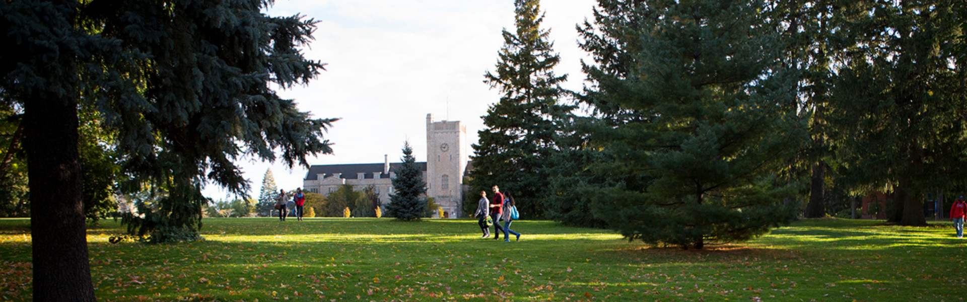 Students walk across Johnston Green on a sunny day, with Johnston Hall in the background.