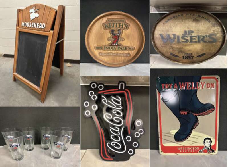 A moosehead chalkboard, an Alexander Keith's oval wooden sign, a Wiser's oval wooden sign, a neon sign depicting a coca cola glass with bubbles around it, a sign for Wellington Brewery that says try a welly on depeting two black rubber boots, and a set of drinking glasses.