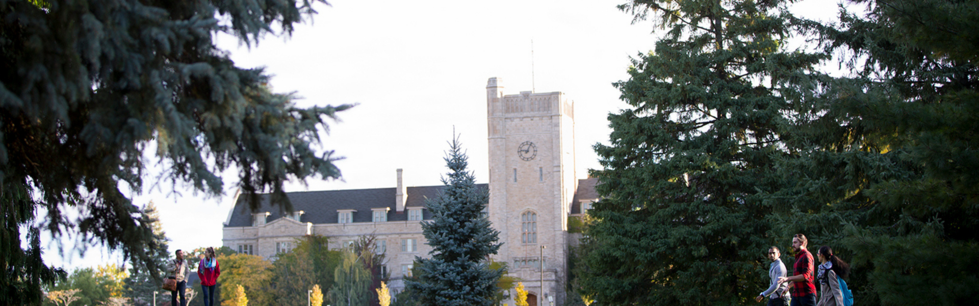 Students walk across Johnston Green in front of Johnston Hall in the summer.