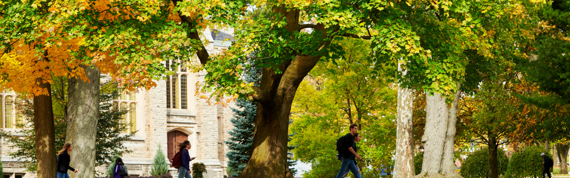 Students walk in front of War Memorial Hall on a fall day.