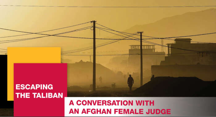 Escaping the Taliban. A conversation with an Afghan female judge. A lone person walks through a city covered in yellow haze.