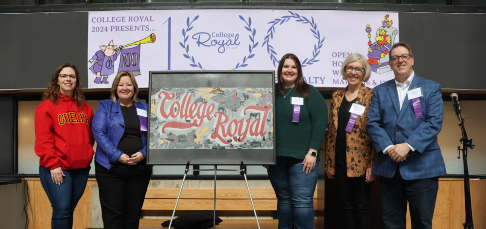 Five people pose for a photo while standing next to a easel showing a depiction of the planned College Royal mural