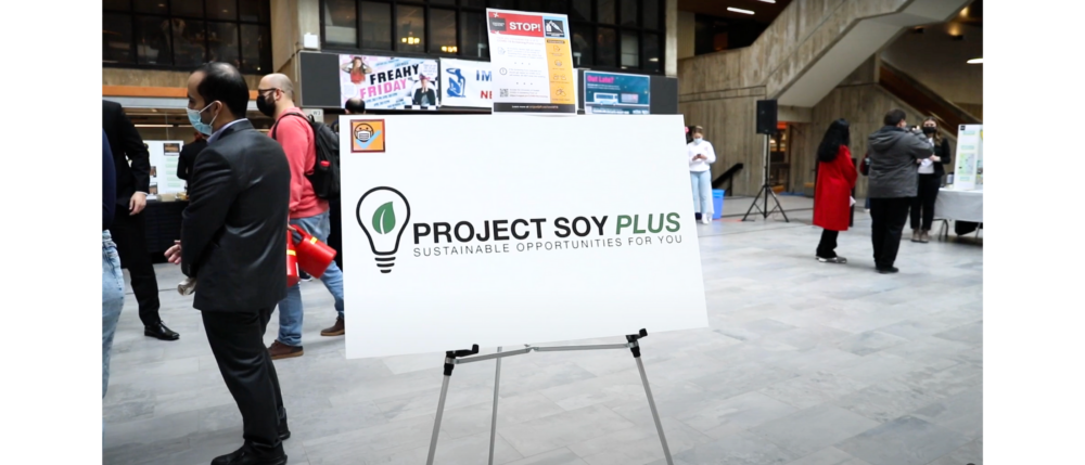 Welcoming banner on stand against the University Centre background, labelled "Project SOY Plus"