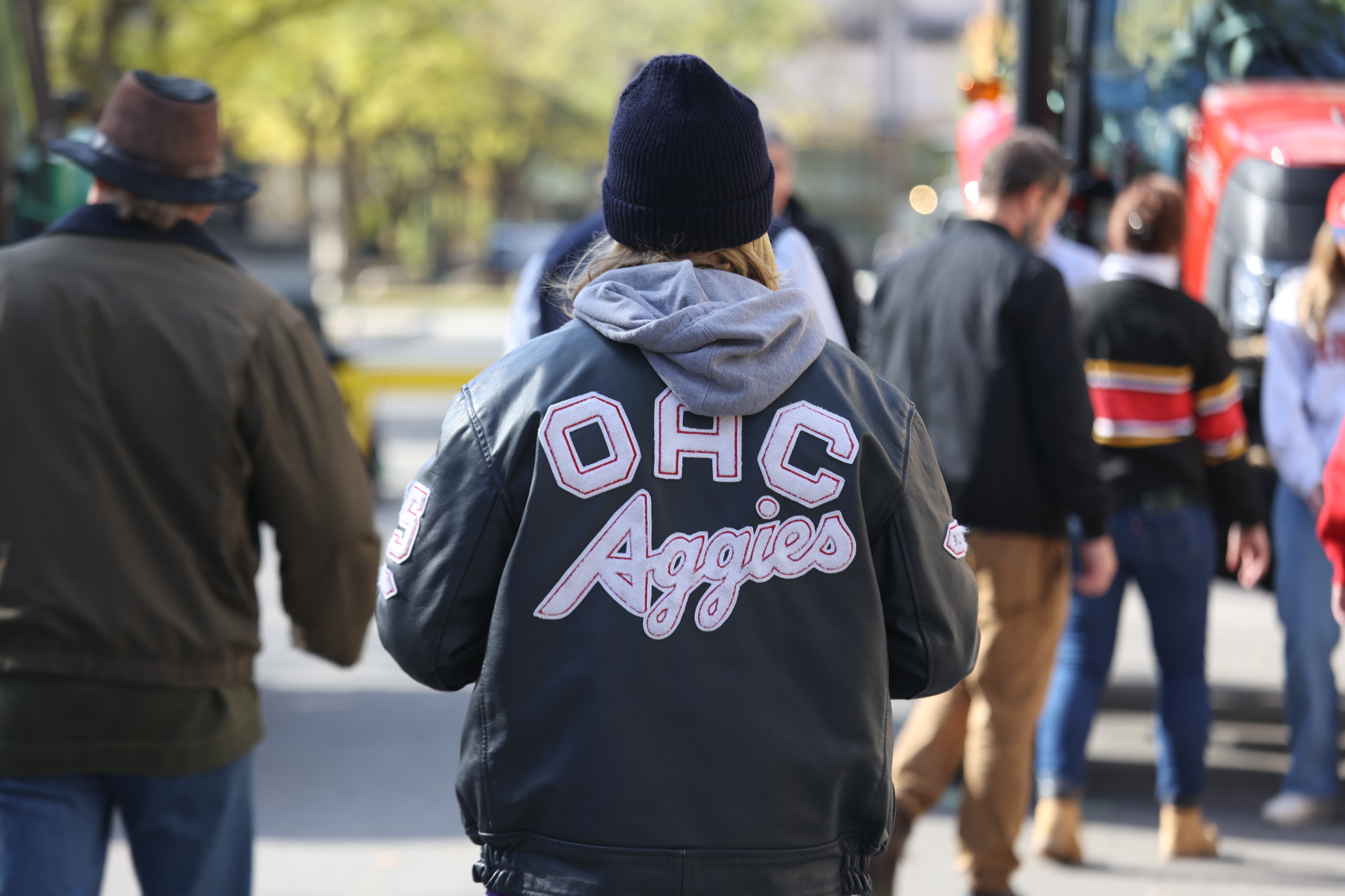 Back shot of person wearing OAC leather jacket, with "OAC Aggies" lettering