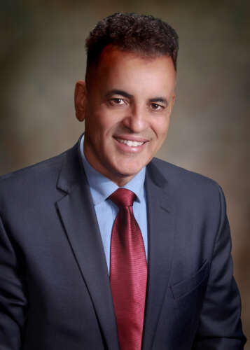 Moncef Nehdi's headshot. He has short dark hair and is wearing a grey blazer with a light-blue shirt and red tie against a blurry background.