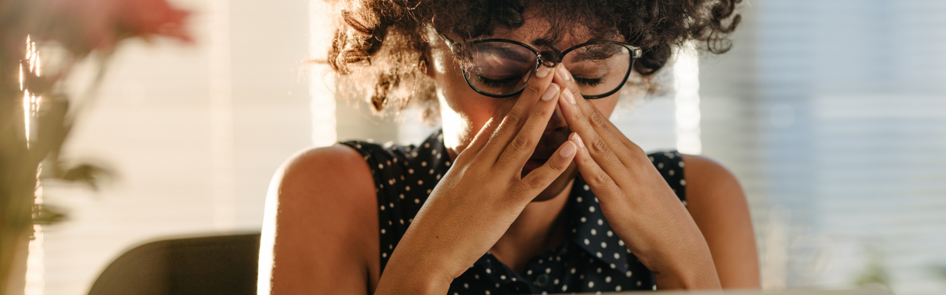 Person in front of a computer stressed with both hands on their face.