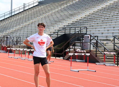 Craig Thorne wears a white shirt with a red maple leaf in front of a grandstand