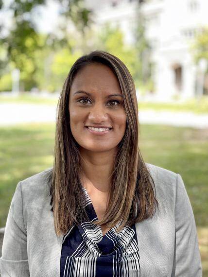 Headshot of Purvi Patel, green field with a walkway in the background of a clear day