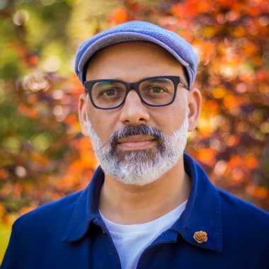 Dr. Faisal Moola poses for a portrait outdoors on a fall day