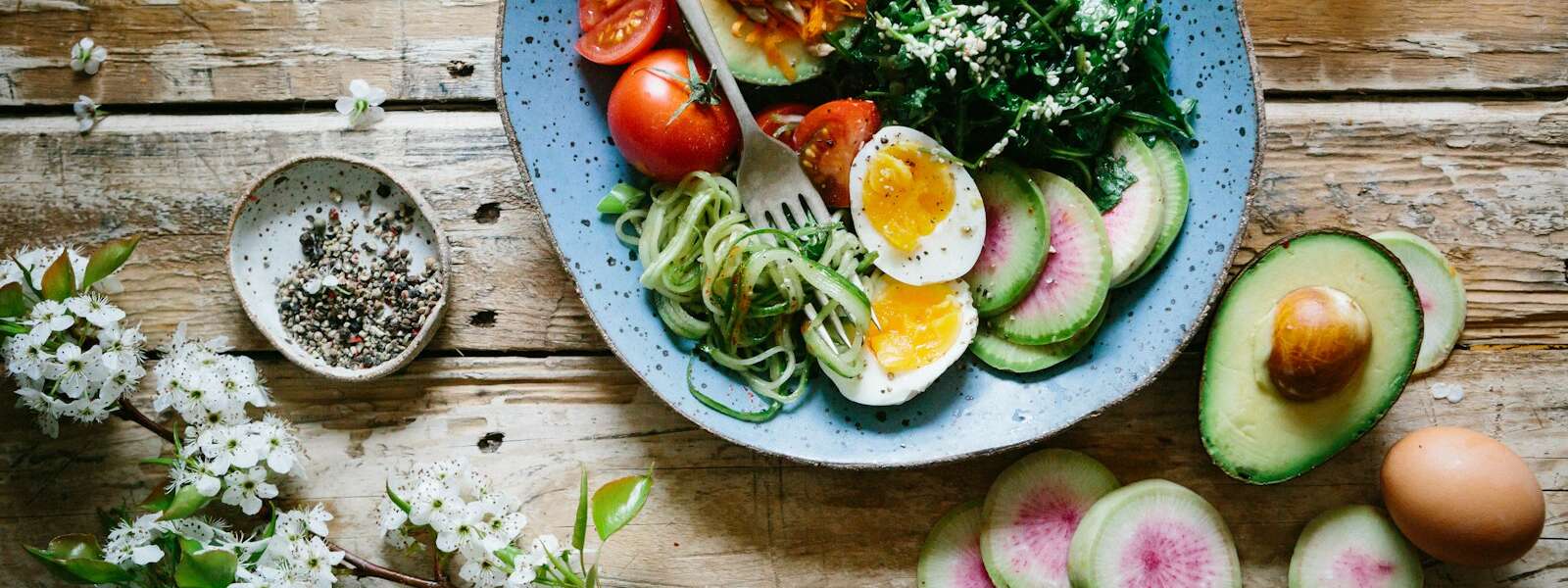 poached egg with vegetables and tomatoes on blue plate