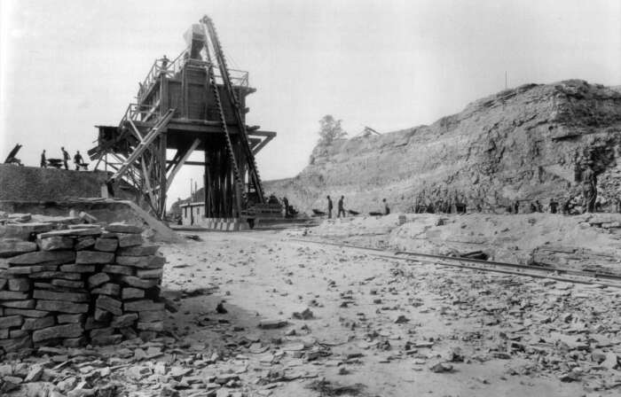 A black and white photo of people working in a quarry.