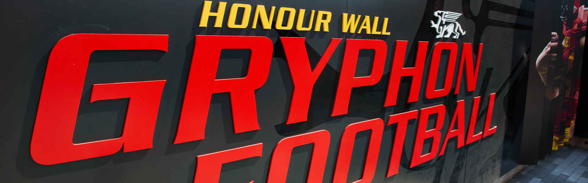 The honour wall, which says Honour Wall Gryphon Football in big letters on a black shiny wall.