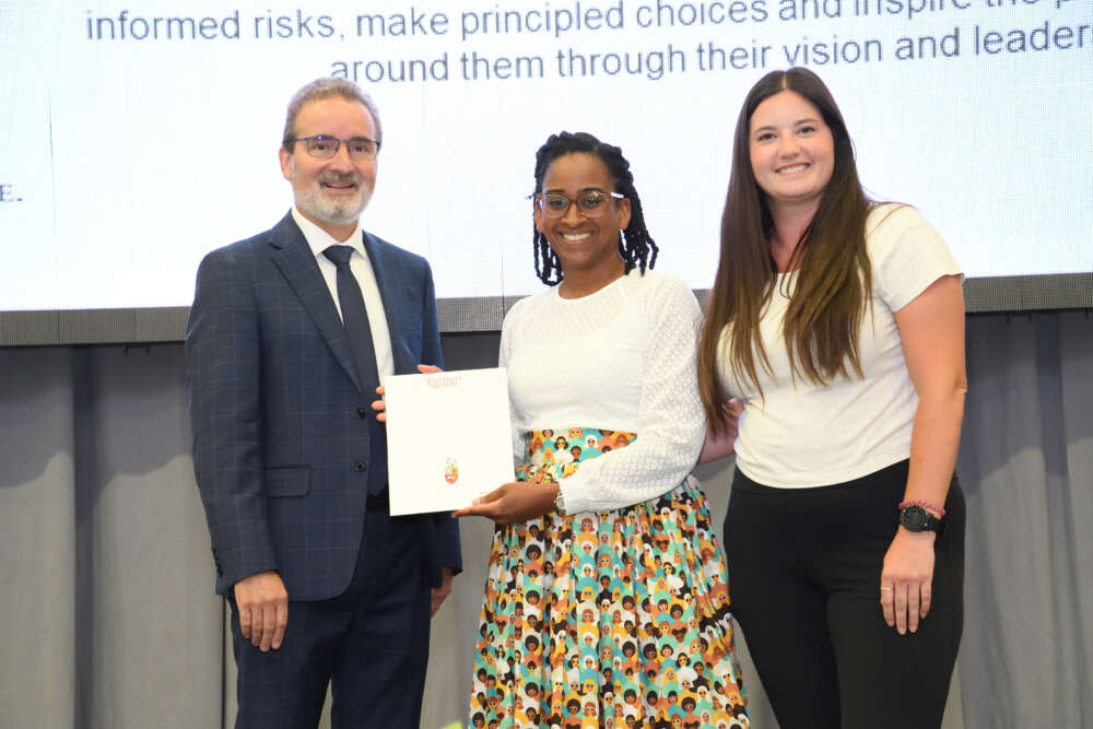 Kimani Rutherford poses with her award, Rene Van Acker, and Madison McGrogan.