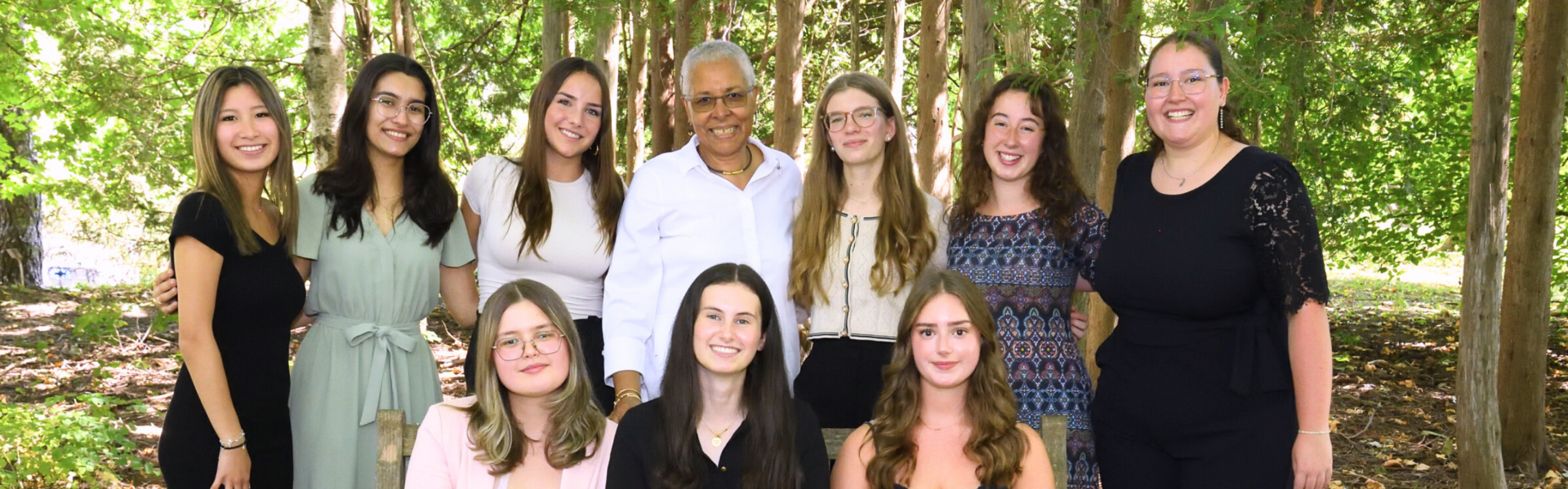 seven women in a back row and three in a front row pose for a group photo