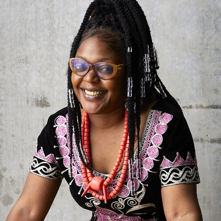 Anna Ngwenyi Mafor poses for a portrait against a concrete wall