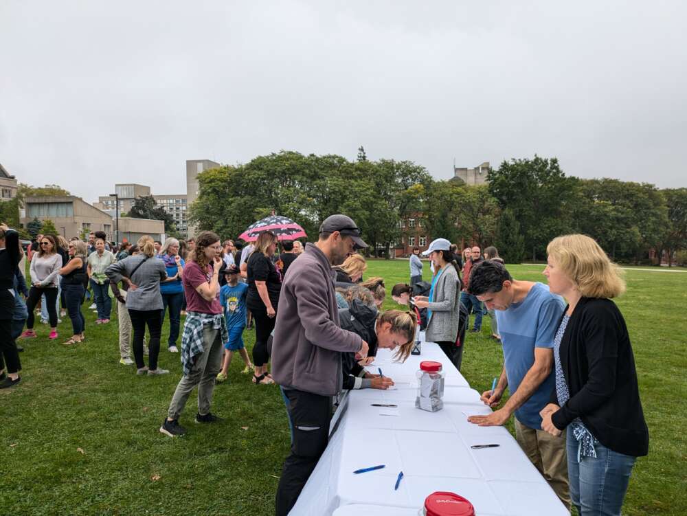 Faculty and staff put their names into a draw for a parking pass at a table on Johnston Green.