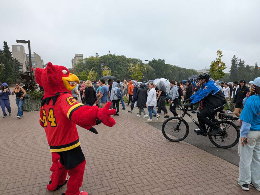 Gryph directs people participating in campus mile.