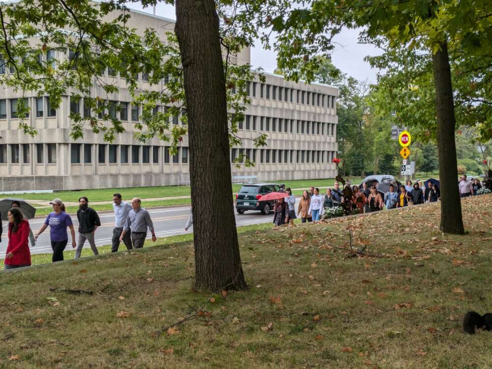 Staff and faculty walk down the sidewalk beside Gordon Street.