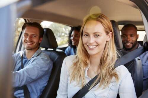 A group of four people ride in a car together.