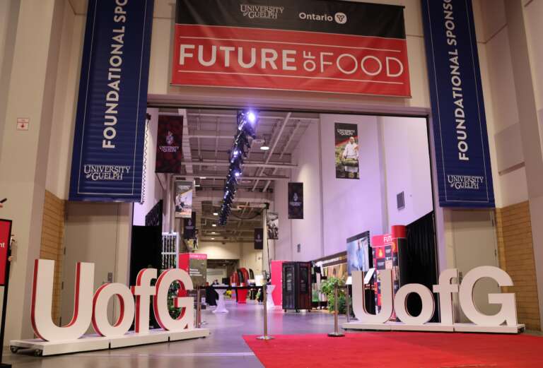 Entrance to a hallway in a large exhibition space, with signs reading U of G and Furture of Food