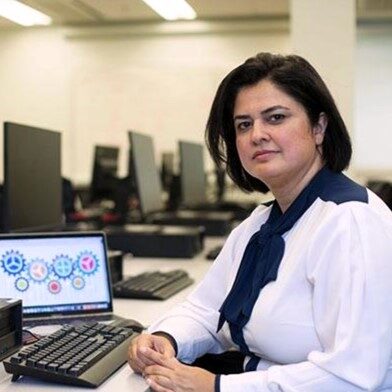 Dr. Rozita Dara sits a computer in a computer lab classroom