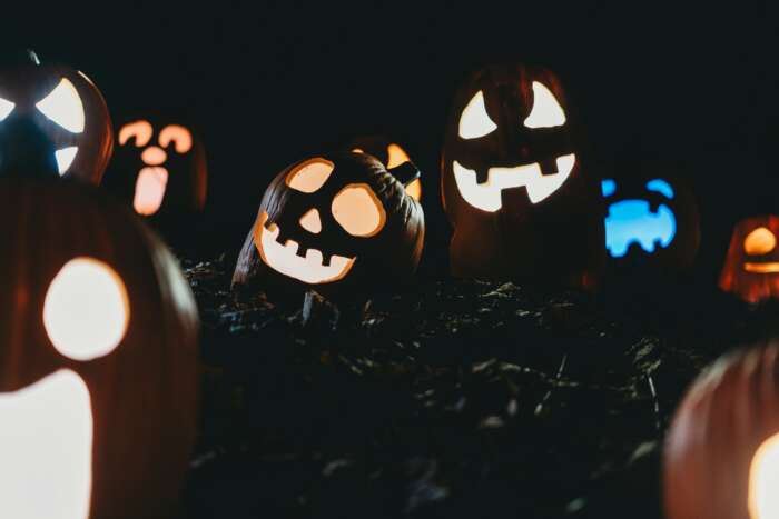 A variety of Jack O Lanterns lit up at night.