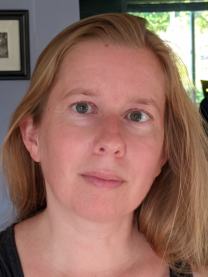 a blonde woman poses for a headshot in front of a window