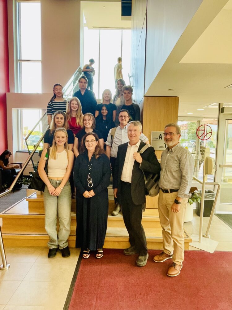 A group of people pose for a group photo up a staircase, consisting of U of G folks and people from Minister Saks' office.