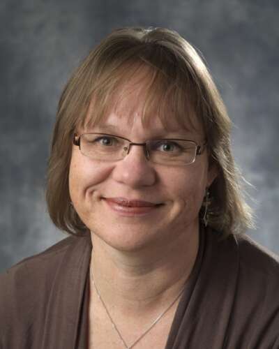 Headshot of Dr. Rebecca Hallett, smiling facing the camera and wearing glasses with shoulder-length light brown hair.