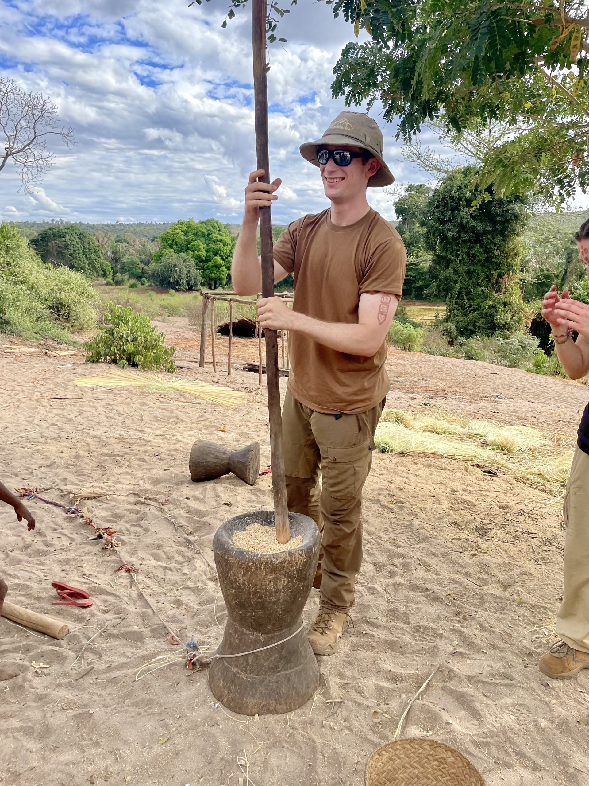 U of G student Hunter Rusk helps process rice in a Malagasy village. 