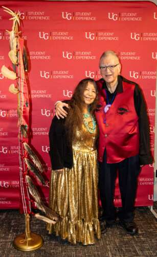 Elder Dan Smoke and Mary Lou Smoke pose in front of a U of G backdrop.